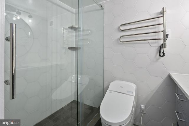 a white toilet sitting next to a shower