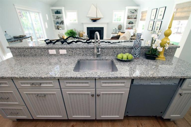 14 Cross Road Mashpee, MA 02649 - Photo 18 of 35 a kitchen with granite countertop a sink a stove and wooden cabinets