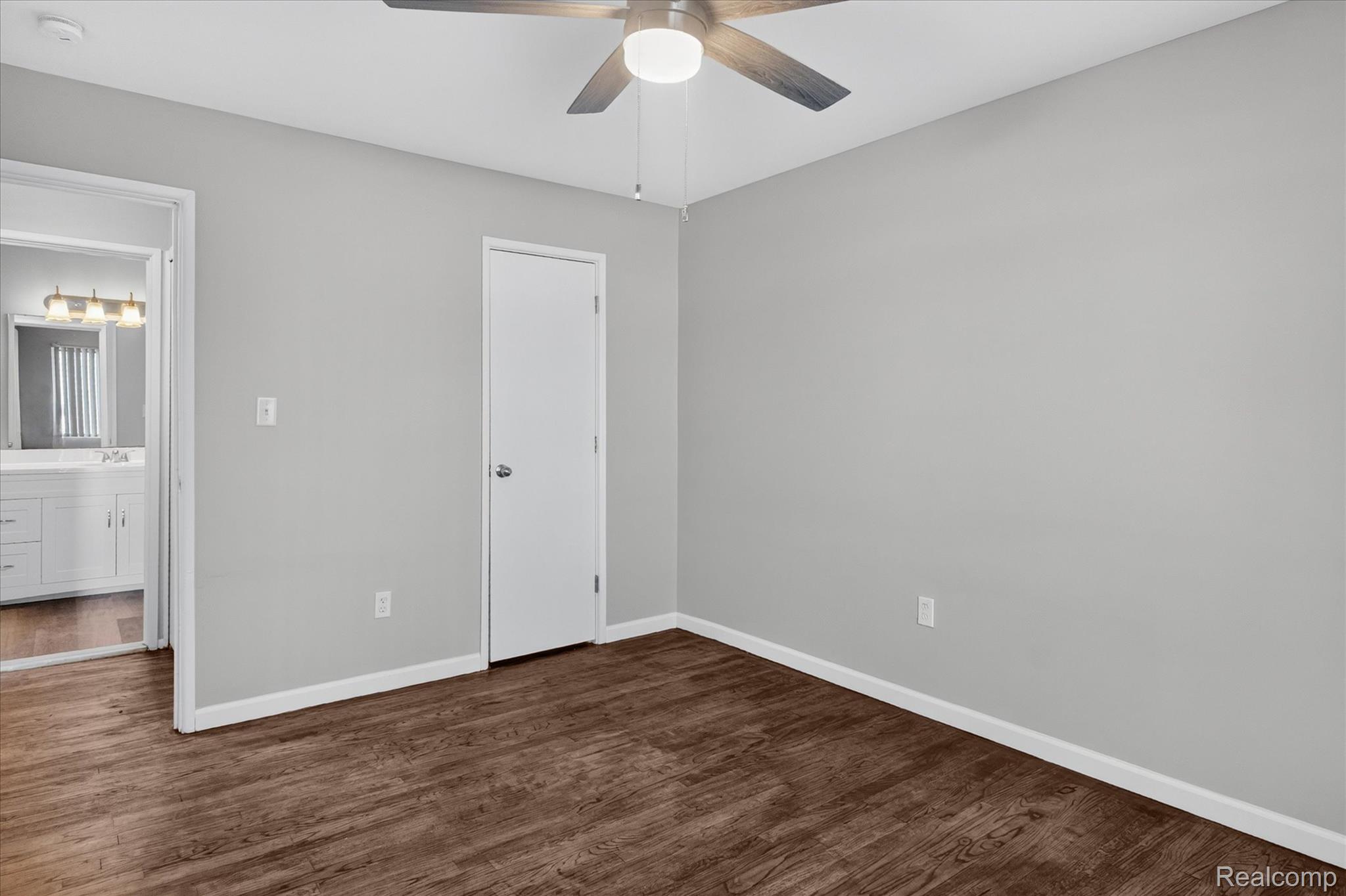 32650 Mound Road, Unit 4 Warren, MI 48092 - Photo 14 of 32 Wood-finish flooring with light gray walls, a white door, and a ceiling fan