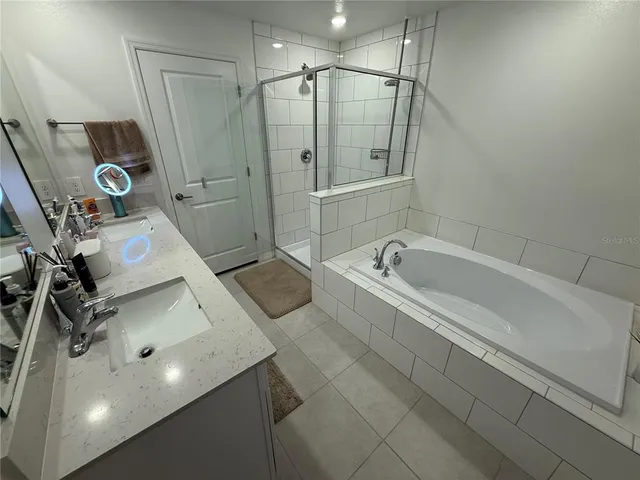 a kitchen with stainless steel appliances granite countertop a refrigerator a stove a microwave a sink and white cabinets