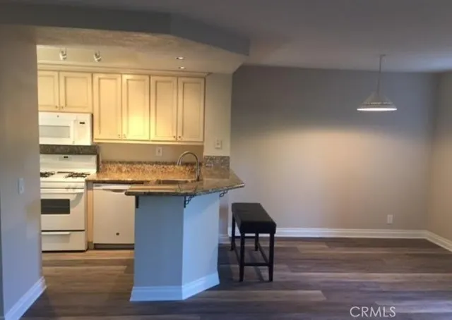 a kitchen with a sink cabinets and wooden floor
