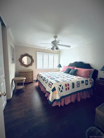 a bedroom with a bed lamps and wooden floor
