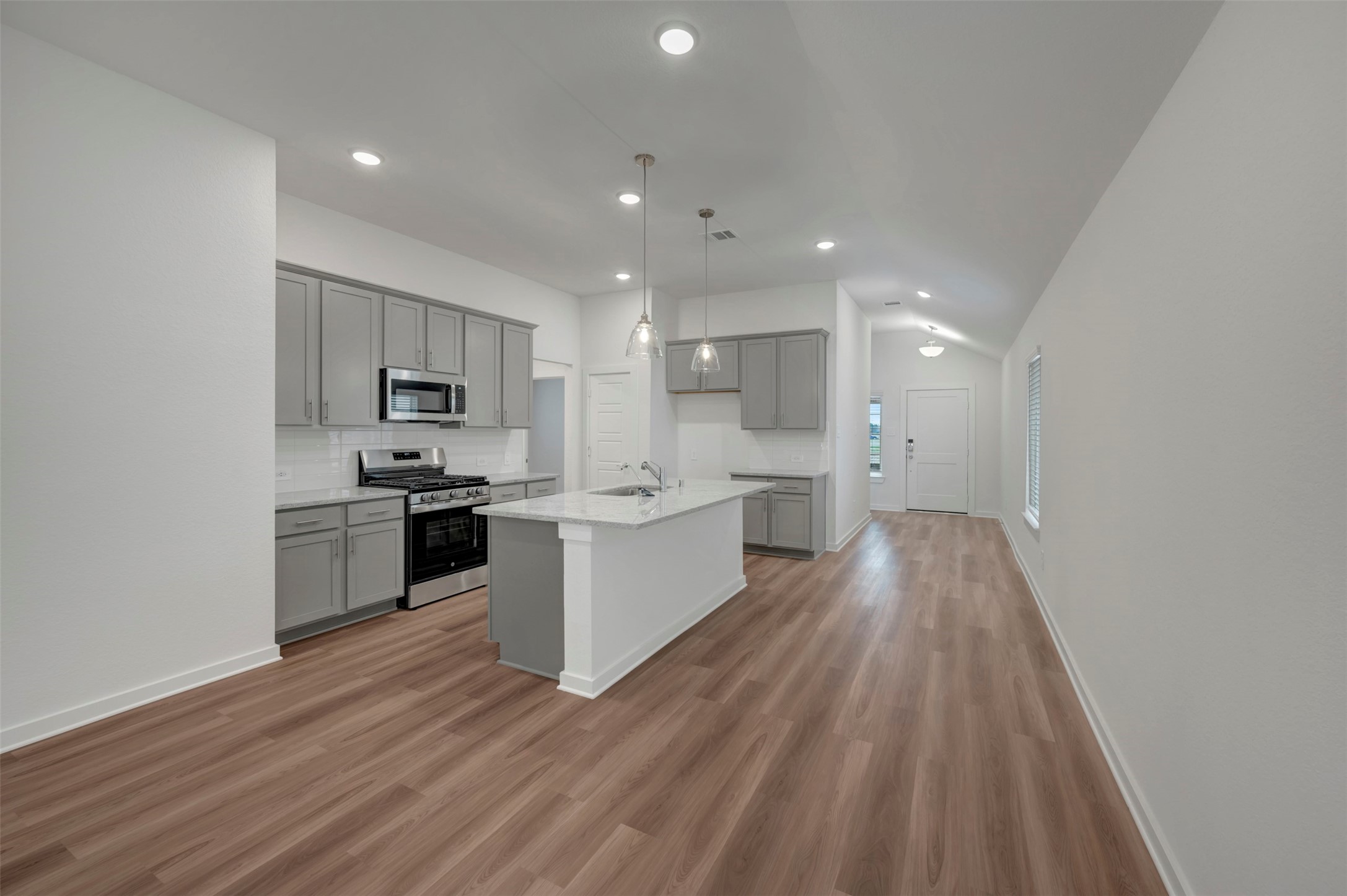 20534 Draper Road Tomball, TX 77377 - Photo 21 of 33 a large kitchen with a large center island wooden floor stainless steel appliances and cabinets