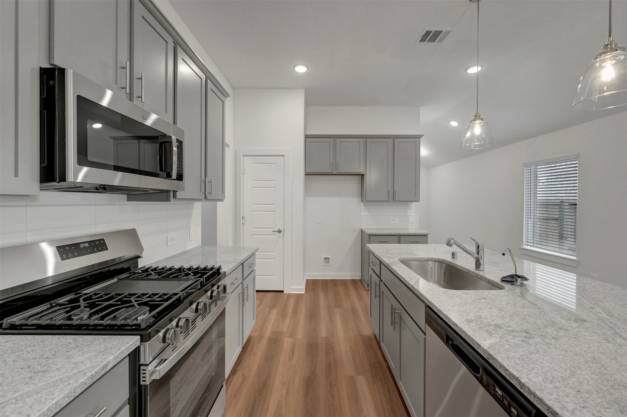 20534 Draper Road Tomball, TX 77377 - Photo 3 of 33 a kitchen with granite countertop a stove and a sink