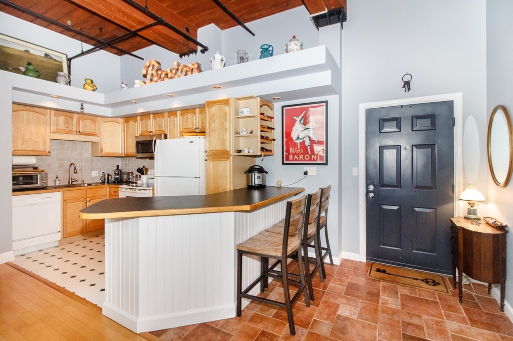 320 West 2nd Street, Unit 412 Boston, MA 02127 - Photo 6 of 16 a kitchen with stainless steel appliances kitchen island granite countertop a refrigerator and microwave