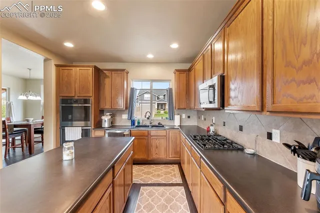 a kitchen with lots of counter top space a sink appliances and cabinets