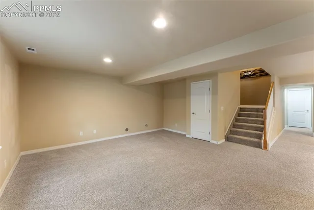 an empty room with windows and stairs