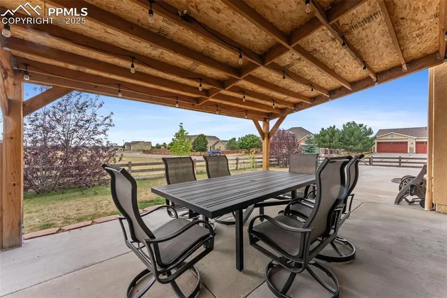 a view of a backyard dining space with furniture and swimming pool