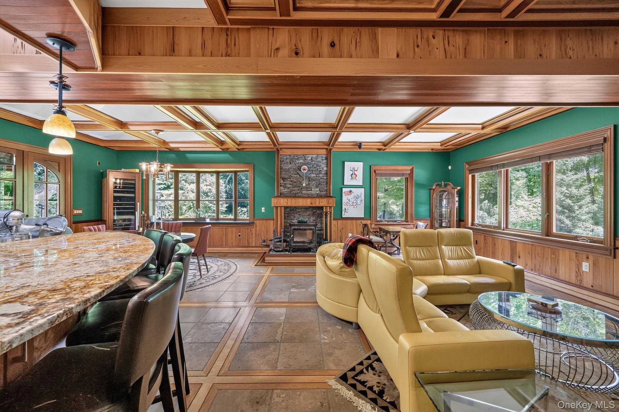23 Inningwood Road Ossining, NY 10562 - Photo 15 of 50 Spacious interior featuring a coffered wood ceiling, stone-surround fireplace with a wood stove, and large windows