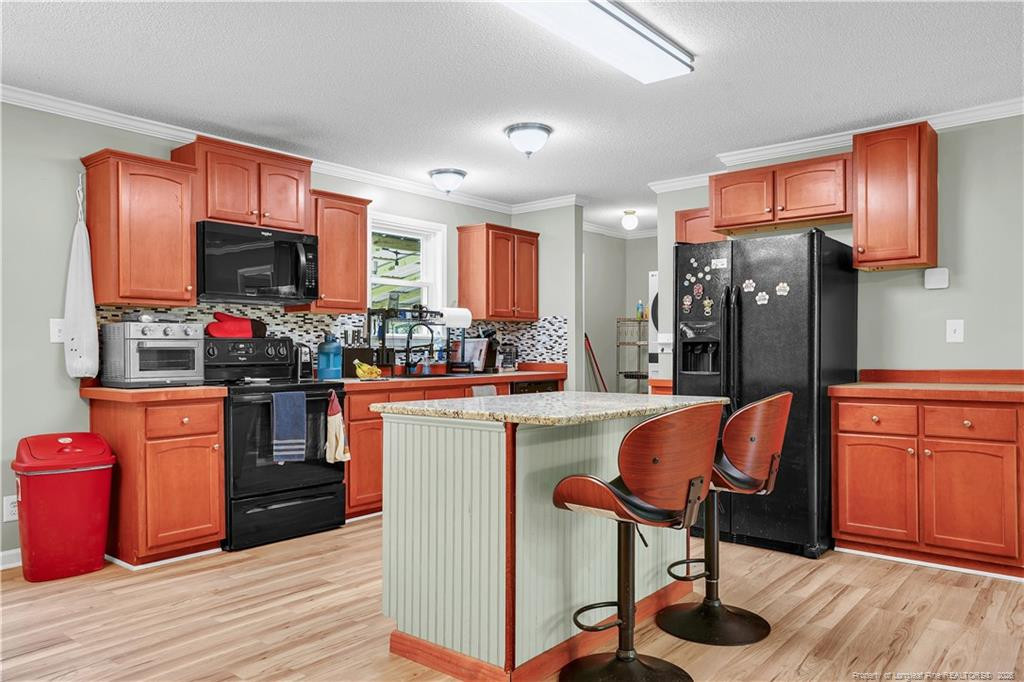 8155 Arabia Road Lumber Bridge, NC 28357 - Photo 8 of 30 a kitchen with stainless steel appliances granite countertop a refrigerator stove top oven a sink and dishwasher