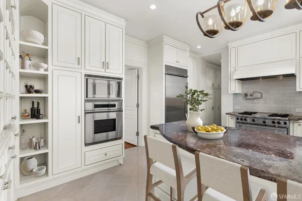 a kitchen with stainless steel appliances kitchen island granite countertop a table and chairs in it