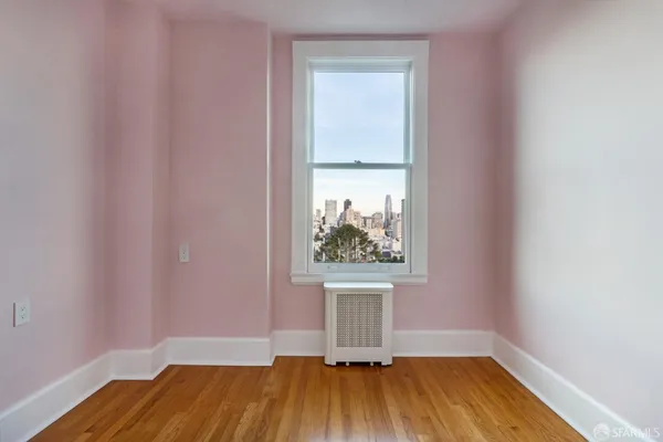 a view of a room with wooden floor and a window