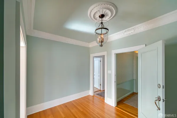 a view of a room with wooden floor and chandelier