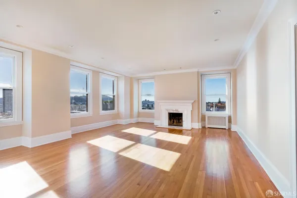 a view of a livingroom with wooden floor and a fireplace
