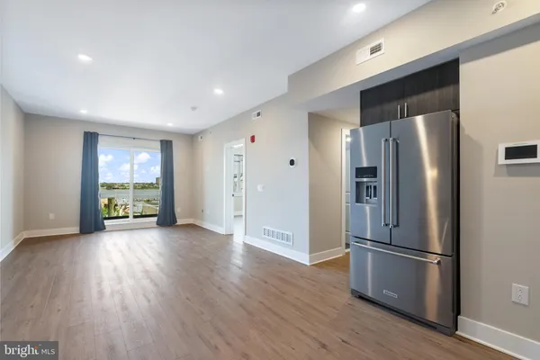 a kitchen with stainless steel appliances a refrigerator and wooden floor