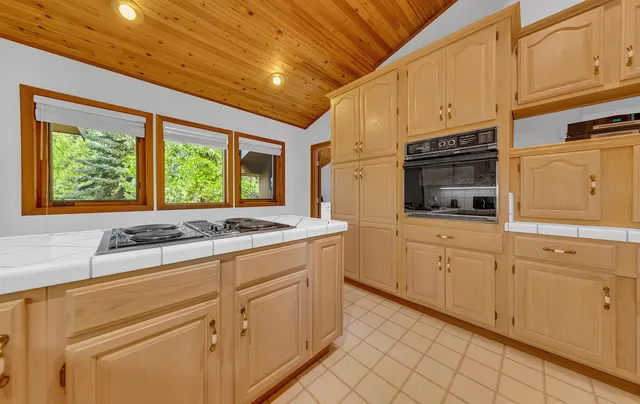 a kitchen with granite countertop white cabinets and white appliances