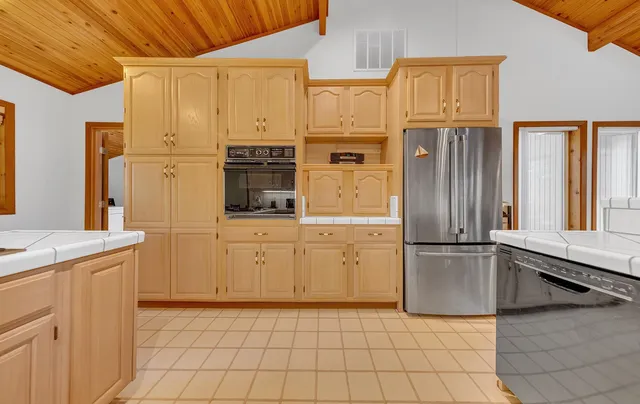 a kitchen with a refrigerator a stove top oven and cabinets