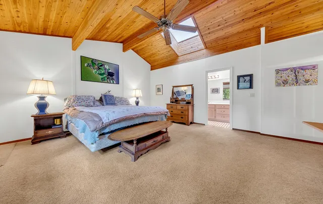 a spacious bedroom with a bed and a lamp