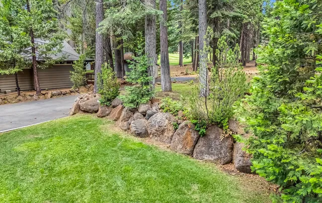 a backyard of a house with lots of green space and fountain