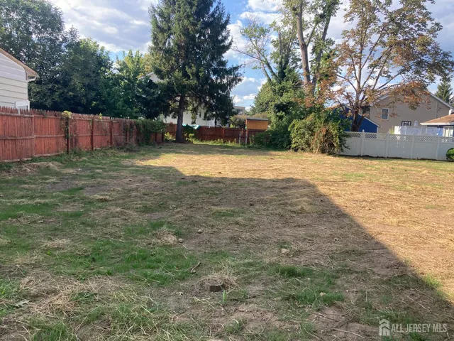 a view of yard with tree and wooden fence