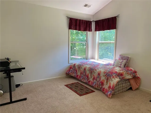 a bedroom with a bed table and a window