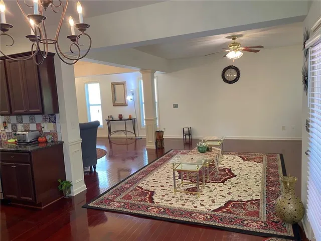 a kitchen with stainless steel appliances wooden floor and chairs