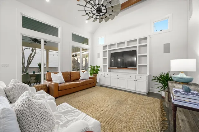a living room with furniture kitchen view and a chandelier