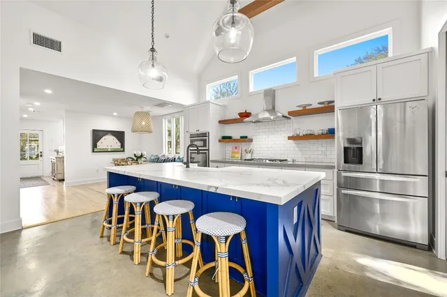 a kitchen with granite countertop a table chairs stainless steel appliances and cabinets