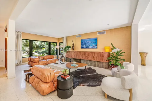 a living room with furniture floor to ceiling window and a potted plant