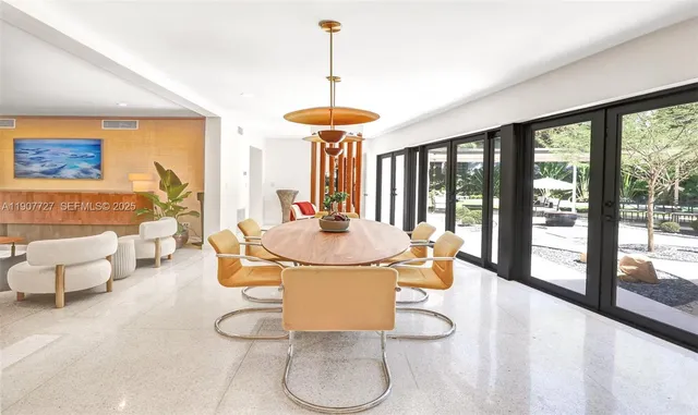 a dining room with furniture and large windows