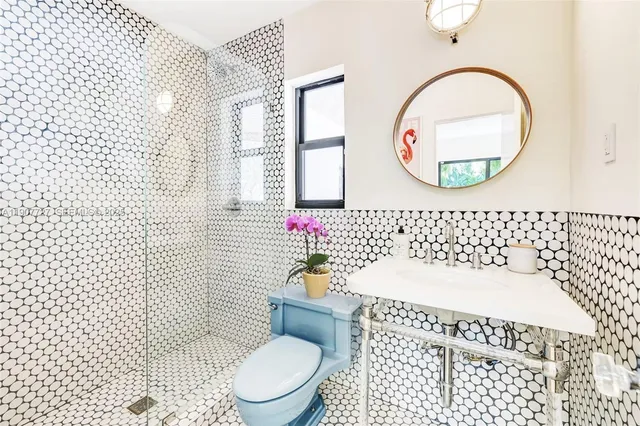 a white toilet sitting next to a bathroom sink