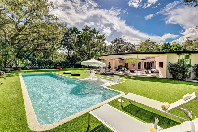 a view of a house with swimming pool and yard