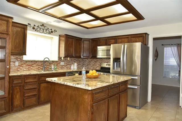 a kitchen with a sink refrigerator and cabinets