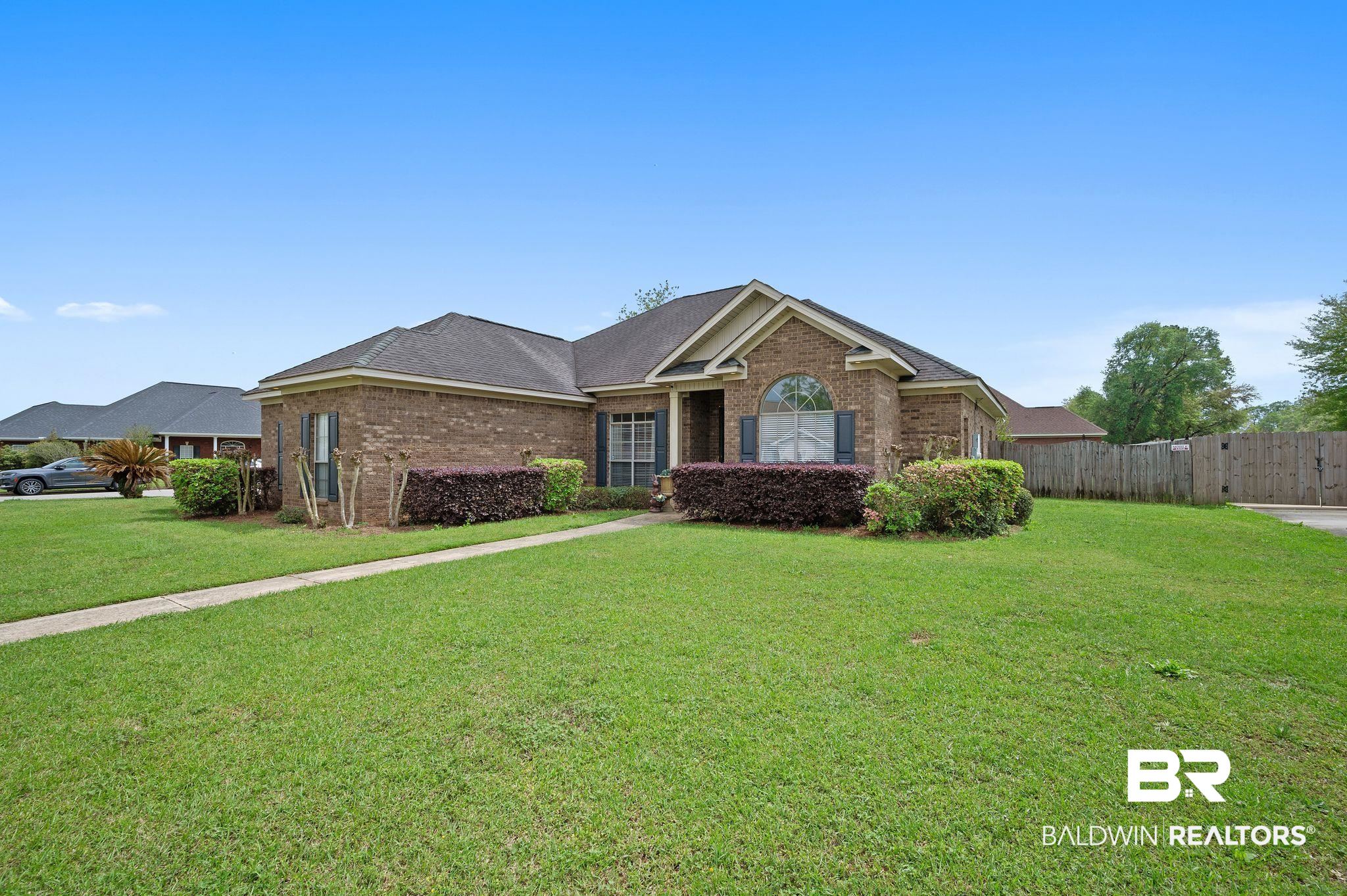 9837 Harmony Ridge Drive Semmes, AL 36575 - Photo 2 of 29 Ranch-style house featuring brick siding, a front yard, and fence