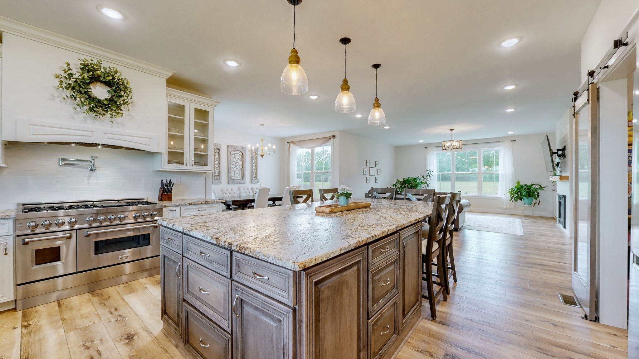 548 Buddy Road Burns, TN 37029 - Photo 3 of 47 a kitchen with stainless steel appliances granite countertop a stove a refrigerator a sink a dining table and chairs with wooden floor