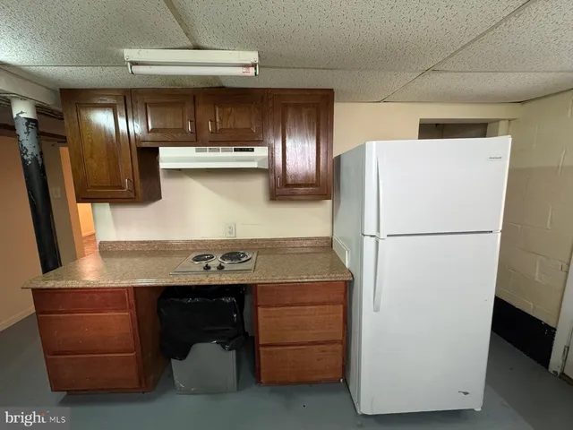 a kitchen with refrigerator and cabinets