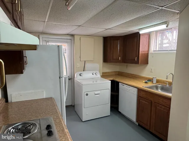 a utility room with sink dryer and washer