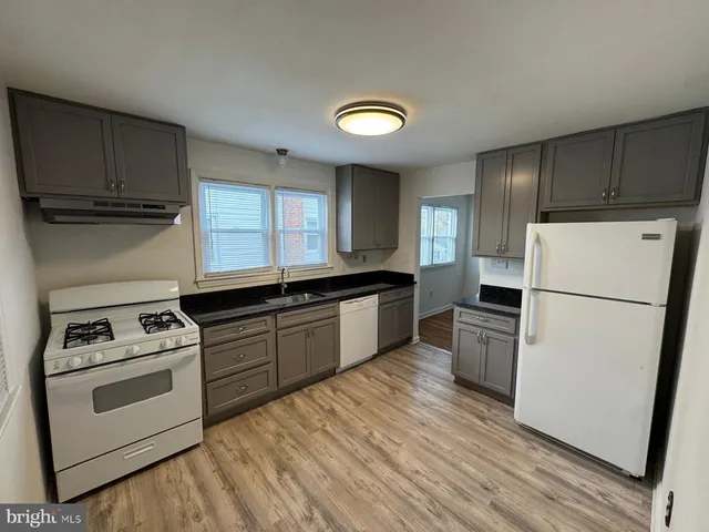a kitchen with a refrigerator stove and wooden cabinets