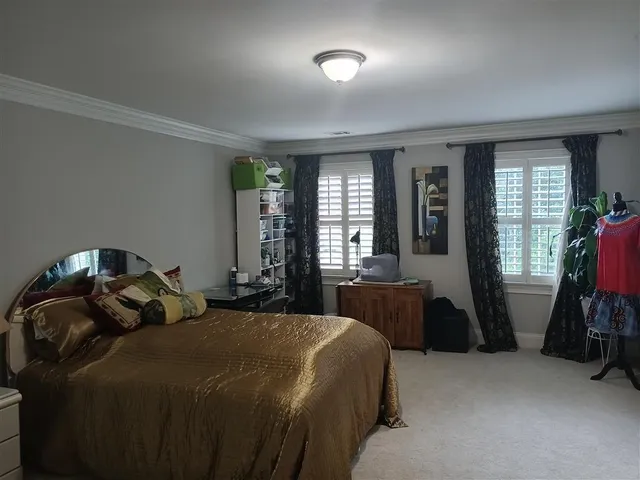 a bedroom with a bed and a large window