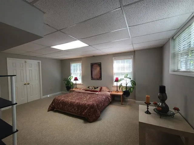 a bedroom with a bed gym equipment and a window