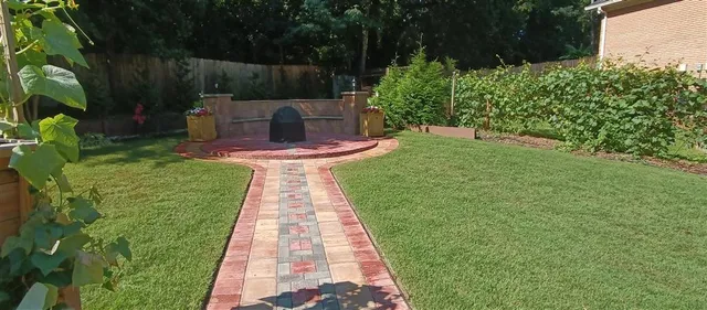 a view of a backyard with couches plants and large tree