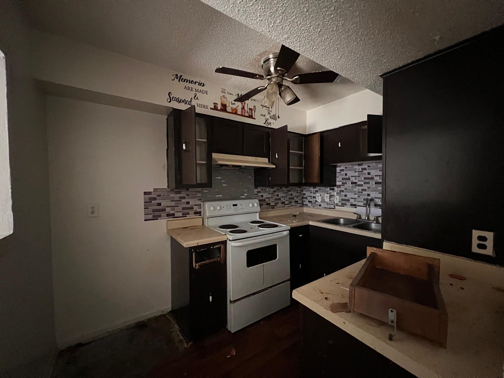 4783 Winchester Road Memphis, TN 38118 - Photo 8 of 14 Kitchen with light countertops, white electric range, decorative backsplash, under cabinet range hood, and a textured ceiling