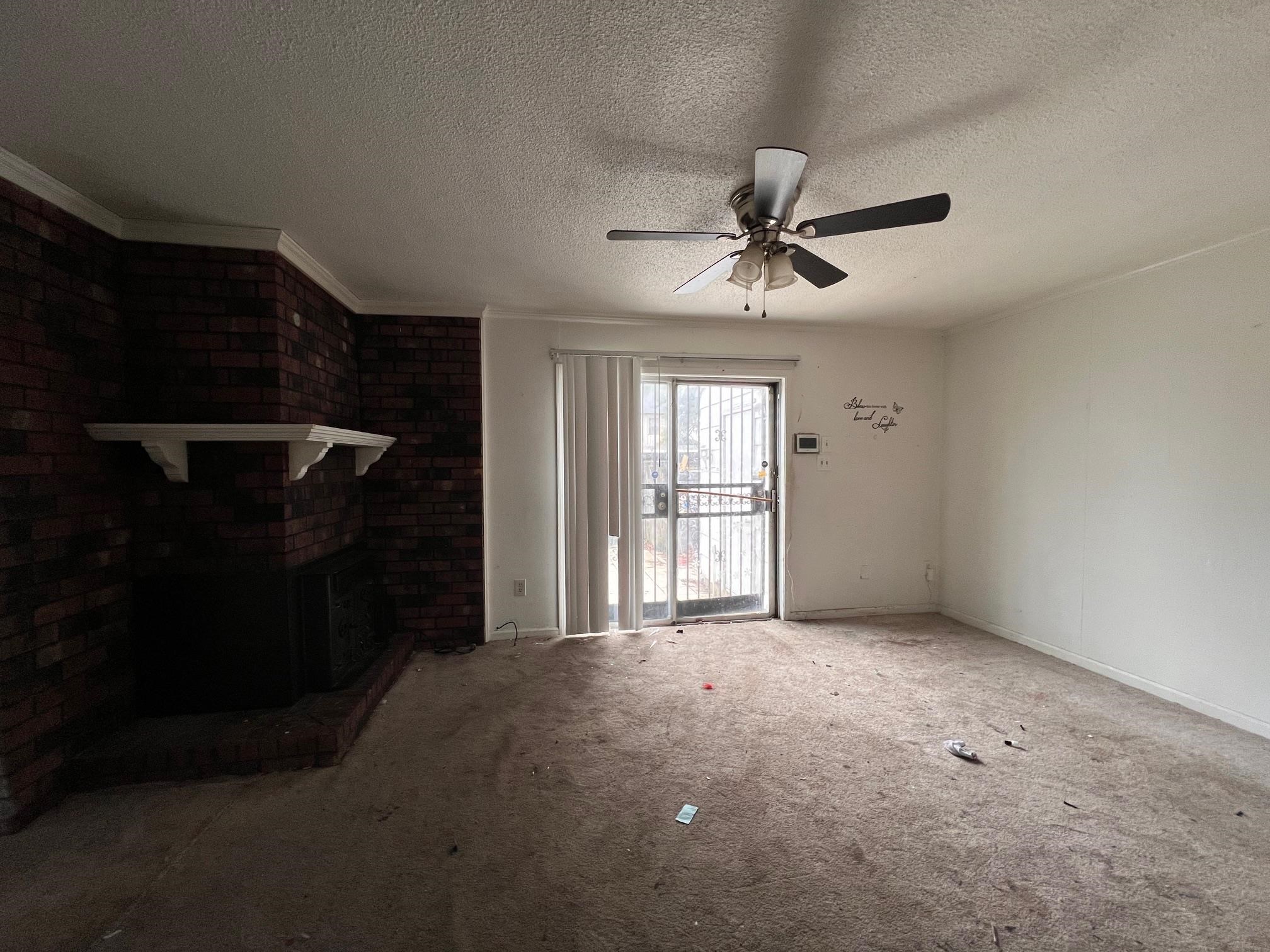 4783 Winchester Road Memphis, TN 38118 - Photo 9 of 14 Unfurnished living room with a fireplace, carpet flooring, a textured ceiling, and ceiling fan