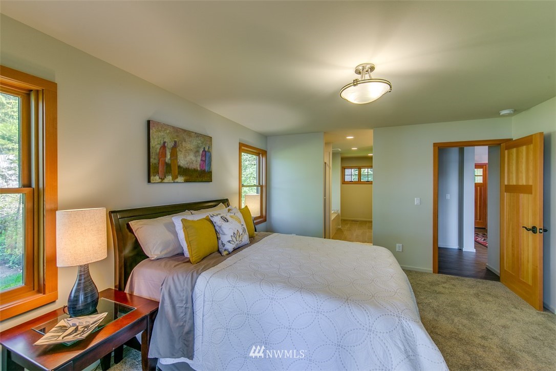 831 Griffith Point Road Nordland, WA 98358 - Photo 14 of 25 a bedroom with a bed and a chandelier