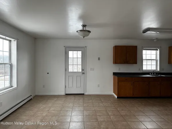an empty room with windows and ceiling fan
