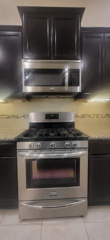 a kitchen with stainless steel appliances granite countertop a sink stove and refrigerator