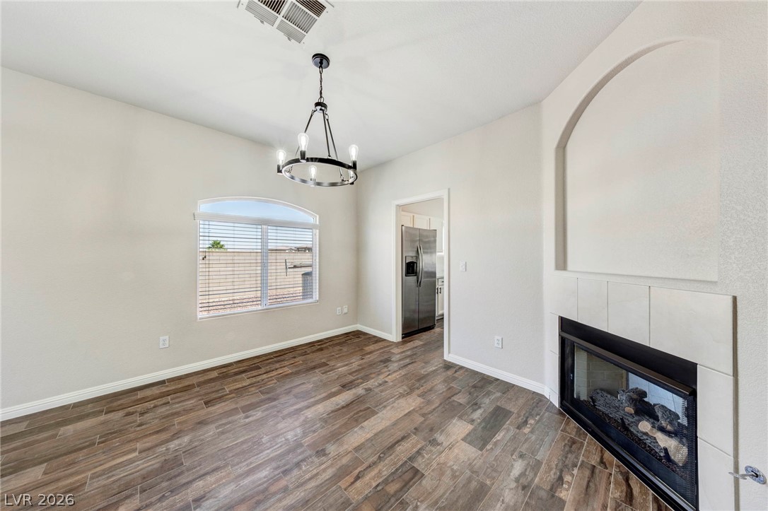 740 Aldo Rae Court, Unit NONE Henderson, NV 89052 - Photo 7 of 35 Natural light pours into this spacious dining area with a modern chandelier and inviting fireplace.