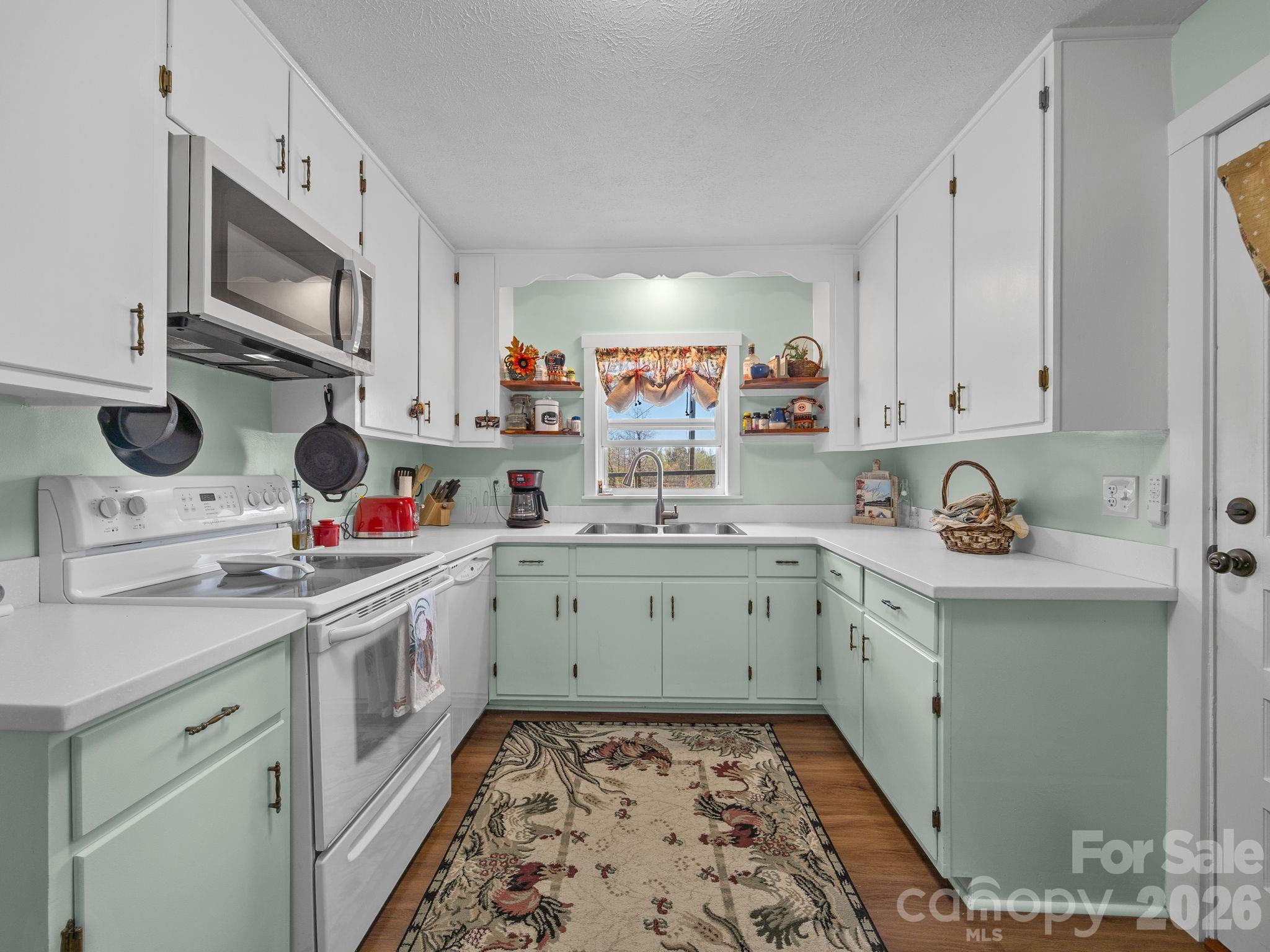 1434 Lake Adger Road Mill Spring, NC 28756 - Photo 12 of 47 a kitchen with a sink stove and microwave