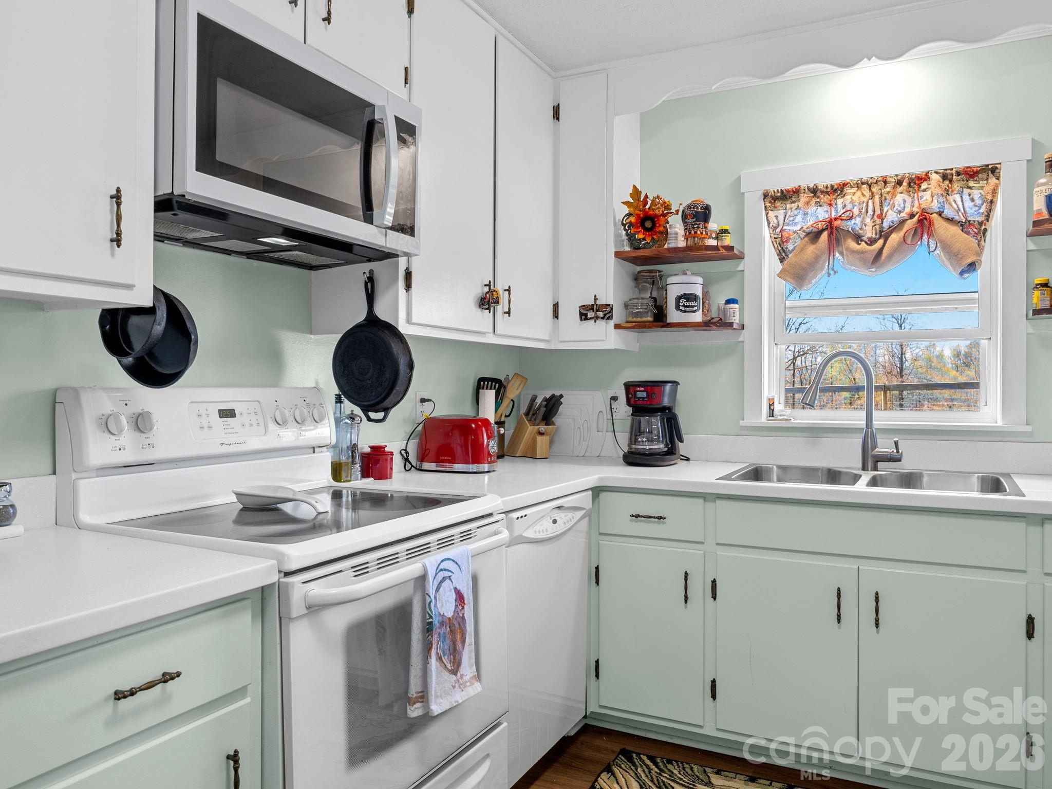 1434 Lake Adger Road Mill Spring, NC 28756 - Photo 13 of 47 a kitchen with stainless steel appliances granite countertop a sink and a microwave