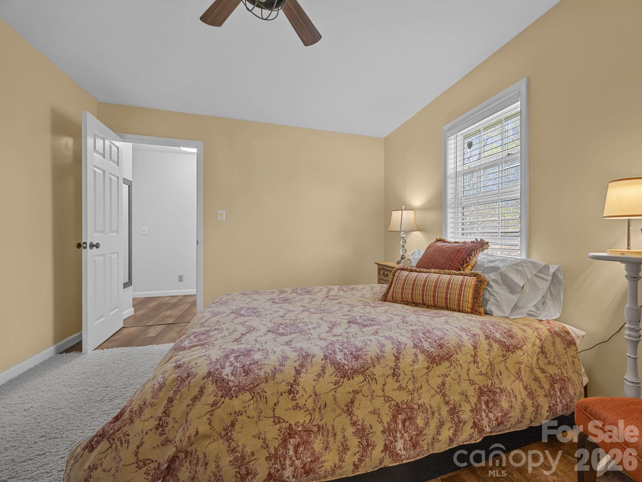 1434 Lake Adger Road Mill Spring, NC 28756 - Photo 16 of 47 a bedroom with a bed and ceiling fan